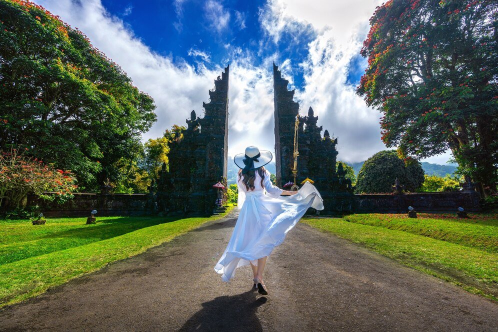 woman-walking-big-entrance-gate-bali-indonesia_335224-380